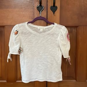 White shirt with puffed up slaves and little bows and  embroidery on the sleeves